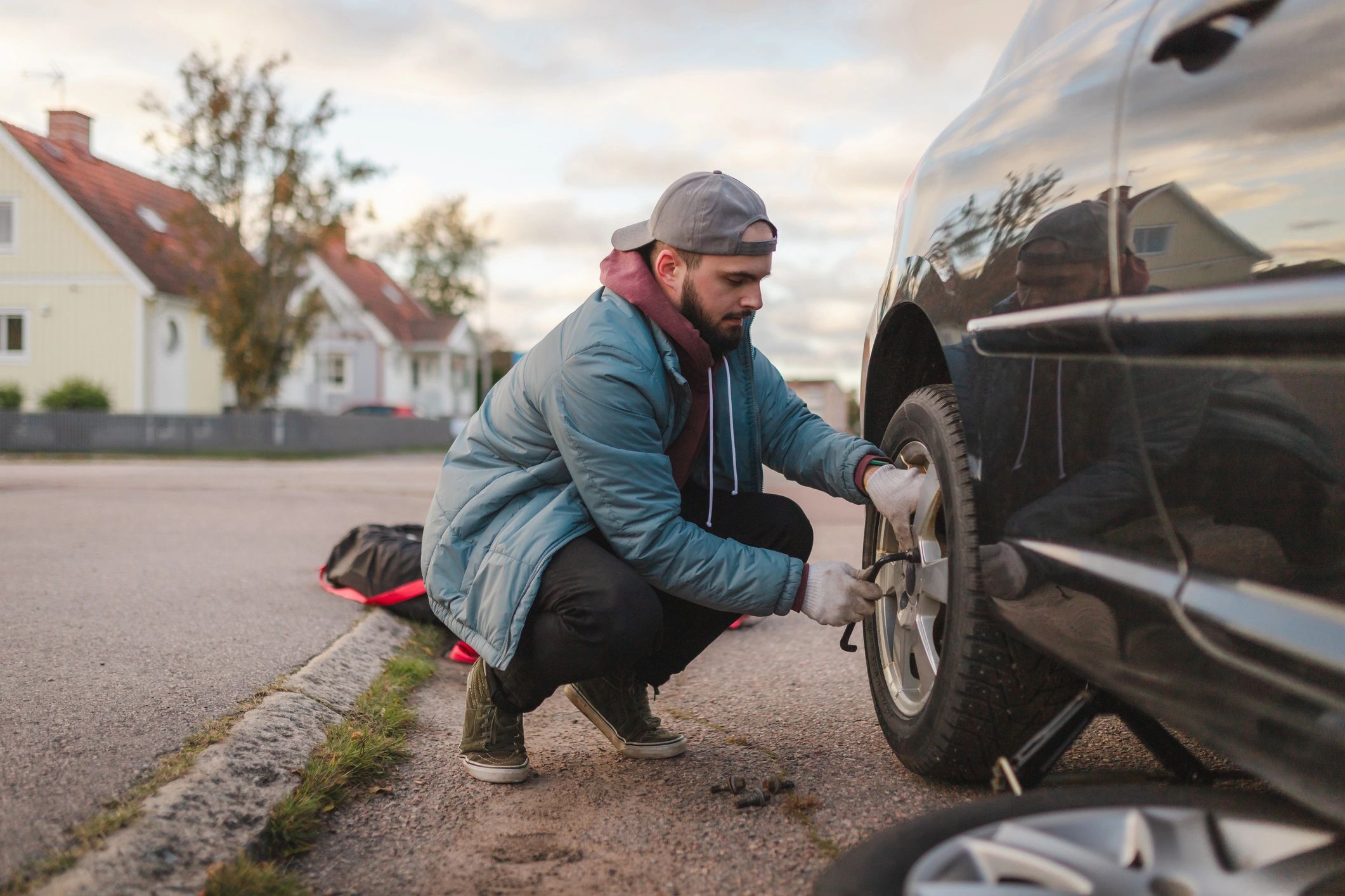 Man changing tire on SUV on street